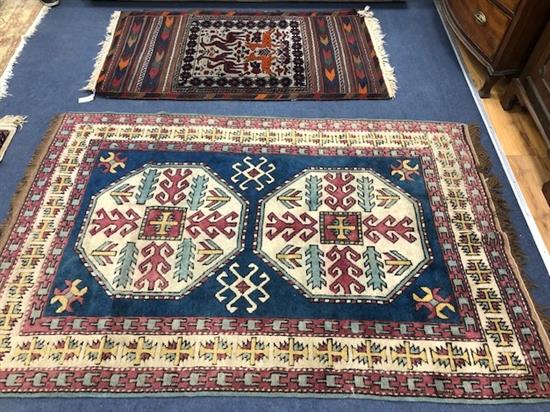 A Turkish blue ground rug with stylised motifs to ivory medallions and geometric borders and a Kilim saddlebag-type rug
